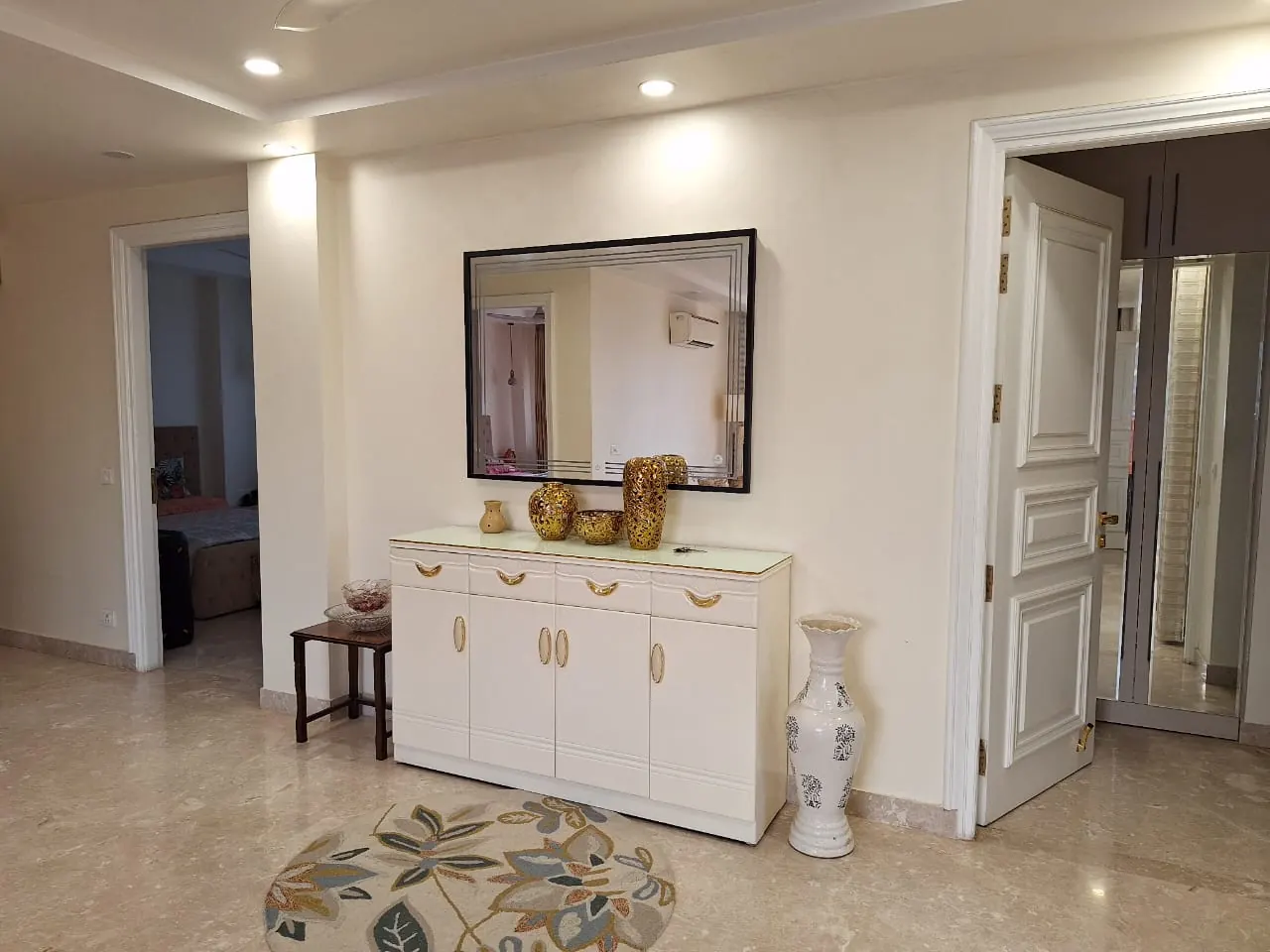 Entrance with white console and mirror, Dehradun home by Nuvasah Interiors