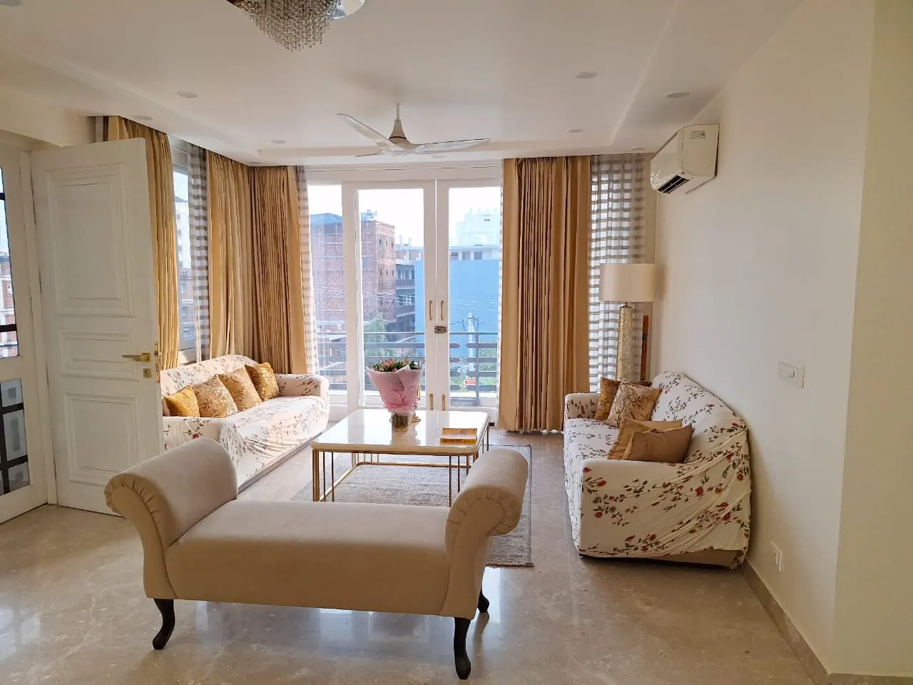 Living room with floral sofas and a cream chaise, Dehradun home by Nuvasah Interiors